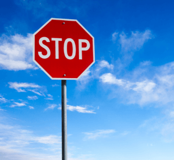 a red octagonal STOP sign with a blue sky in the background