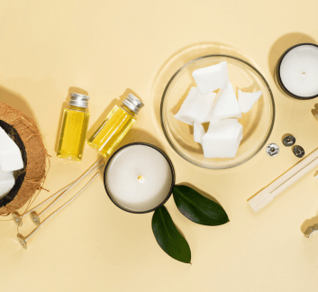 coconut oil, candles, and wooden utensils on a yellow background