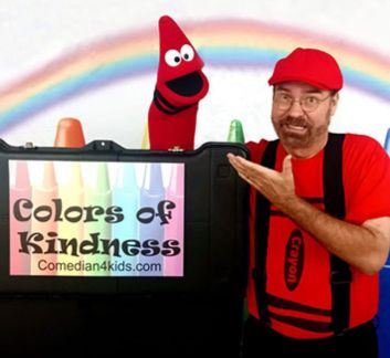 Man in red hat with a red crayon puppet. Rainbow in background & 